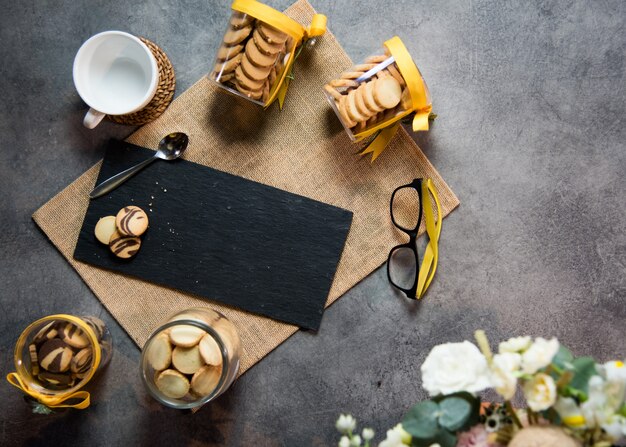 Xícara de café vista superior com biscoitos e superfície de mármore preto