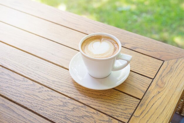 Xícara de cappuccino da manhã na mesa de madeira