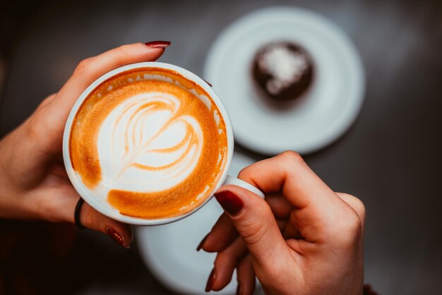 Xícara de cappuccino nas mãos