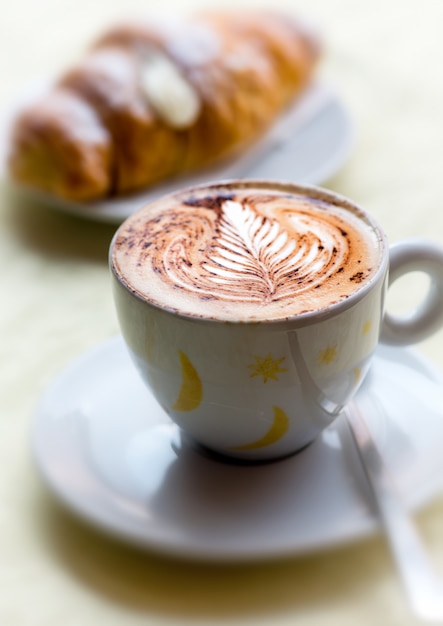 Xícara de cappuccino quente com brioche