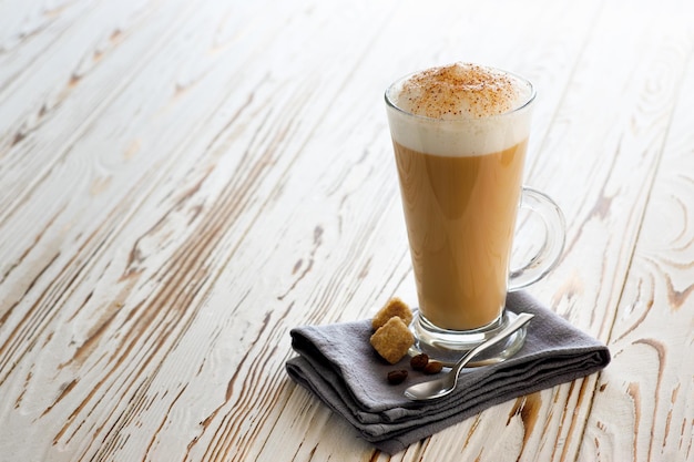 Xícara de capuccino na mesa de madeira branca