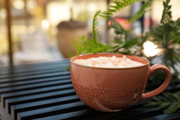 Xícara de cerâmica de café aromático com espuma na mesa de madeira no café Espaço para texto