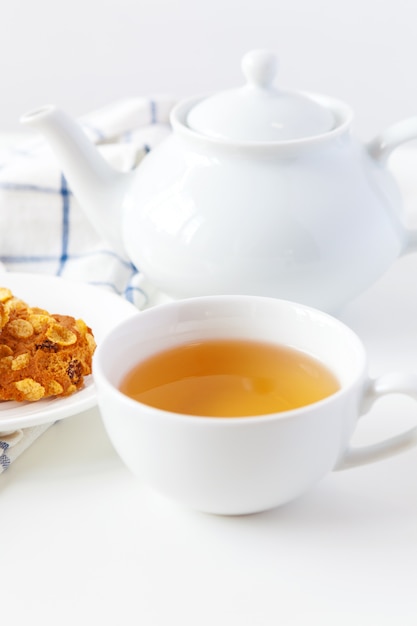 Xícara de chá com biscoitos sobre fundo lilás de madeira