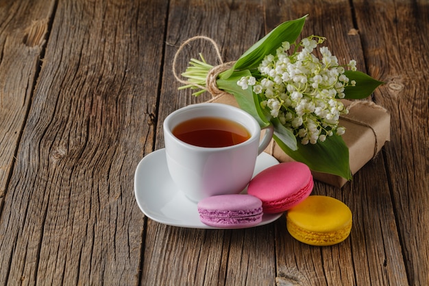 Xícara de chá com decoração de flores brancas na mesa de madeira