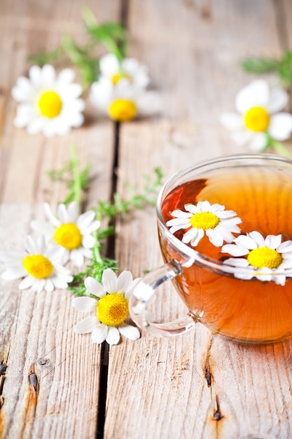 Xícara de chá com flores de camomila