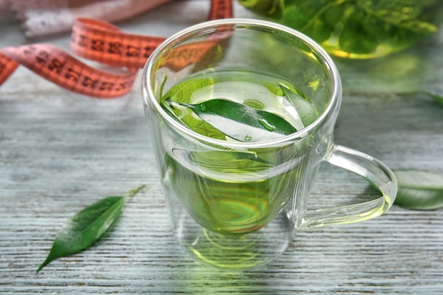 Xícara de chá com folhas na mesa de madeira Conceito de perda de peso