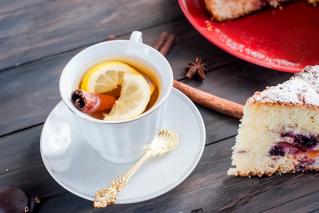 Xícara de chá com limão e uma torta de frutas