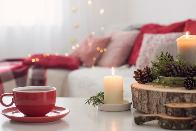 Xícara de chá com queima de velas na mesa branca