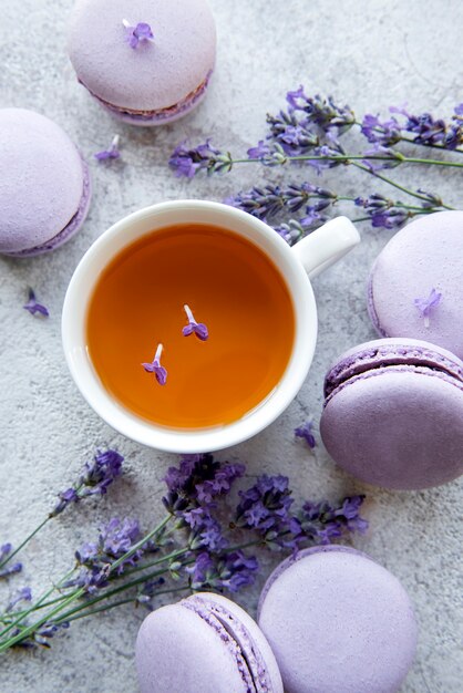 Xícara de chá com sobremesa de macaroon com sabor de lavanda e flores frescas de lavanda