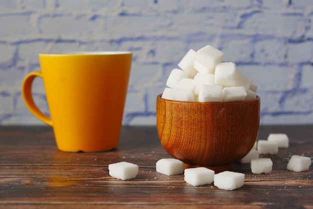 Xícara de chá e cubo de açúcar na mesa