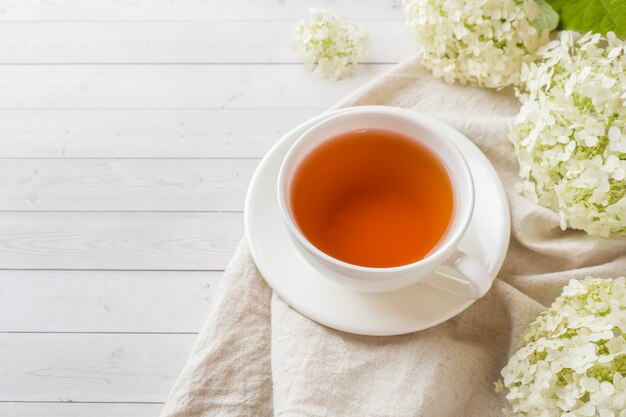 Xícara de chá na mesa com flores. café da manhã aconchegante