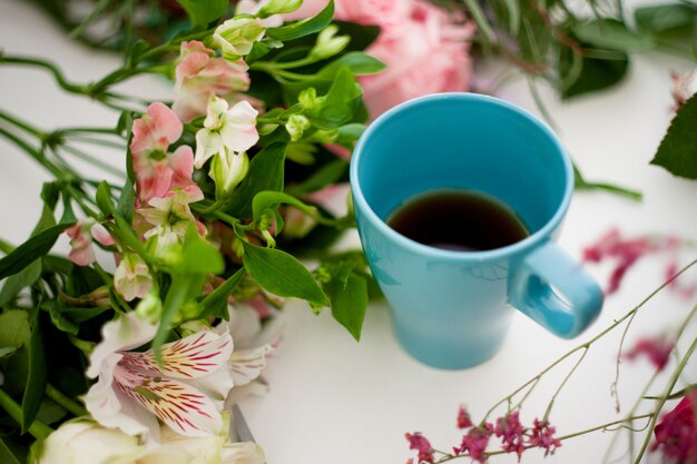 Xícara de chá na mesa, relaxe. oficina florista, mesa com flores, ainda vida. foco suave