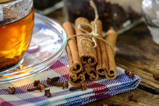 Xícara de chá natural e aromática com canela e cravo em estilo vintage