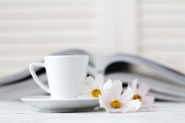 Xícara de chá no livro com flor.