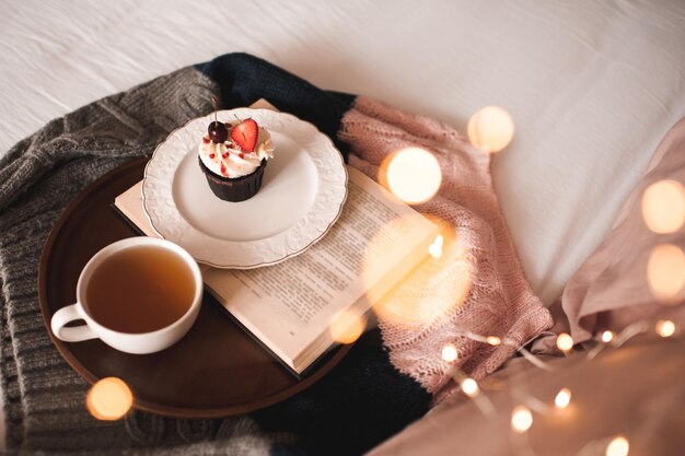 Xícara de chá verde com bolinho saboroso e livro aberto