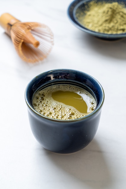 xícara de chá verde matcha quente com pó de chá verde e bata