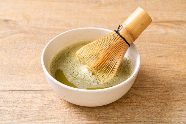 xícara de chá verde matcha quente com pó de chá verde e bata