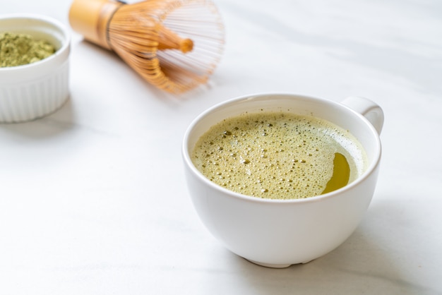 xícara de chá verde matcha quente com pó de chá verde e bata