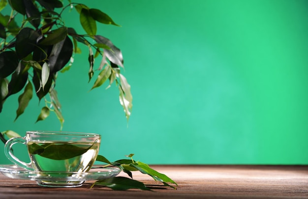 Xícara de chá verde na mesa sobre fundo verde