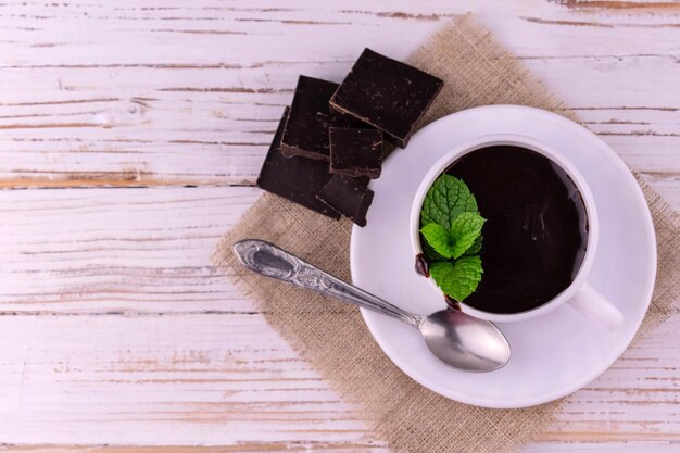 Xícara de chocolate quente branco fundo de madeira camada liso espaço para texto