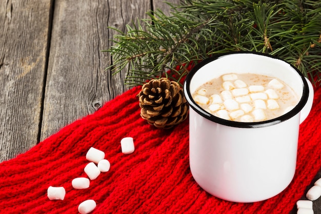 Xícara de chocolate quente com creme e marshmallows no escuro