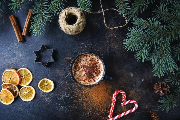 Xícara de chocolate quente ou cacau com creme de baunilha decoração de natal sobre fundo de pedra escura