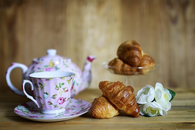 Xícara de croissant café da manhã com fundo de madeira