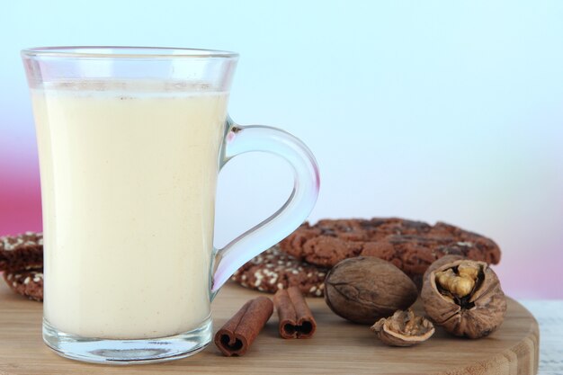 Xícara de gemada com canela e biscoitos na mesa no fundo brilhante