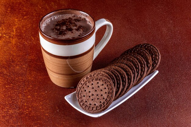 Xícara de leite com cacau e biscoitos de chocolate