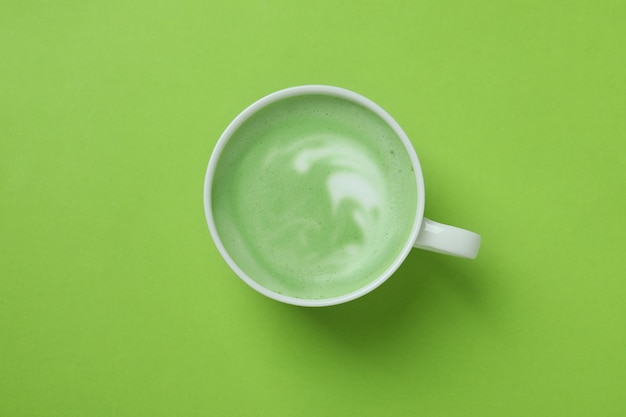 Xícara de matcha latte em fundo verde