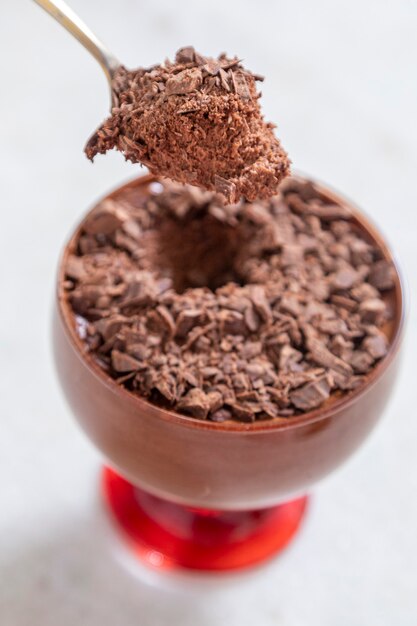 Foto xícara de sobremesa com mousse de chocolate ao leite com raspas de chocolate branco