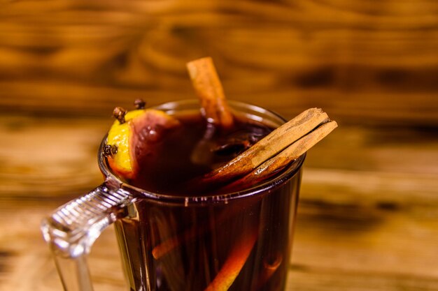 Xícara de vinho quente com canela na mesa de madeira rústica