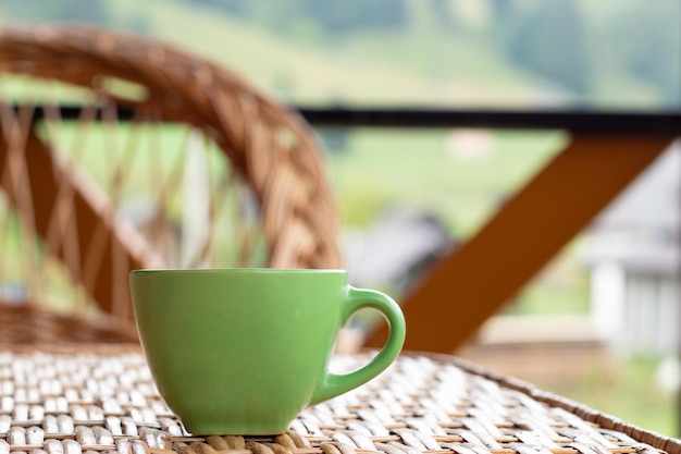 Xícara verde de café ou chá no terraço contra o fundo da natureza Relaxamento do conceito de natureza