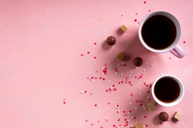 Xícaras de café, chá, chocolate doce de doces em fundo de corações rosa. Conceito mínimo de dia dos namorados 14 de fevereiro. Camada plana, acima, vista superior, espaço de cópia