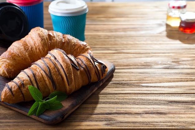 Xícaras de café e dois croissants na rua em Croissant Cafe