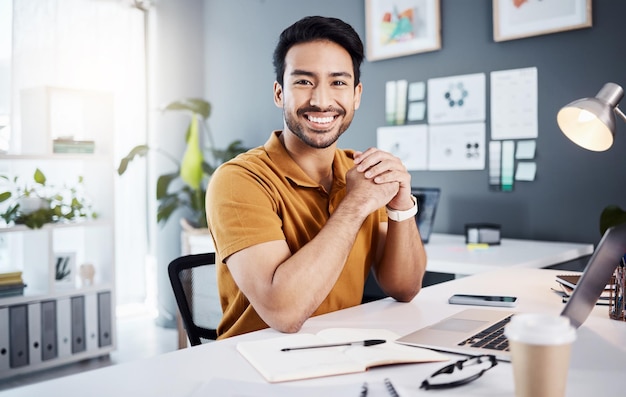 Éxito de confianza y retrato de un hombre de negocios en la oficina mientras trabaja en un proyecto con una computadora portátil Sonrisa feliz y un informe corporativo de planificación de empleados masculinos profesionales con una computadora en el lugar de trabajo