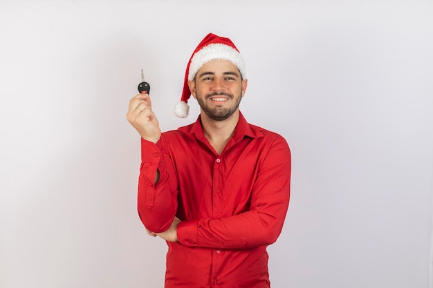 Éxito felicidad sueño diciembre comprador propiedad propiedad compra alquiler venta camión coches concepto Guapo en traje tradicional rojo de Navidad y sombrero en la cabeza sosteniendo una llave de coche