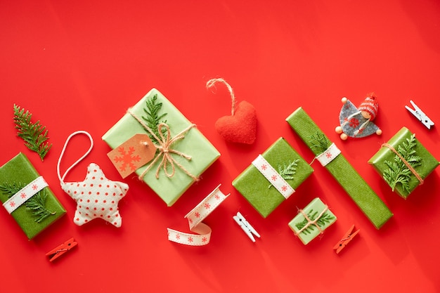 Xmas vermelho e verde. Eco zero resíduos presentes de Natal ou ano novo. Lay diagonal geométrico. Caixas embrulhadas em papel reciclado amarrado com cordão ou fita de algodão e decoradas com sempre-vivas.