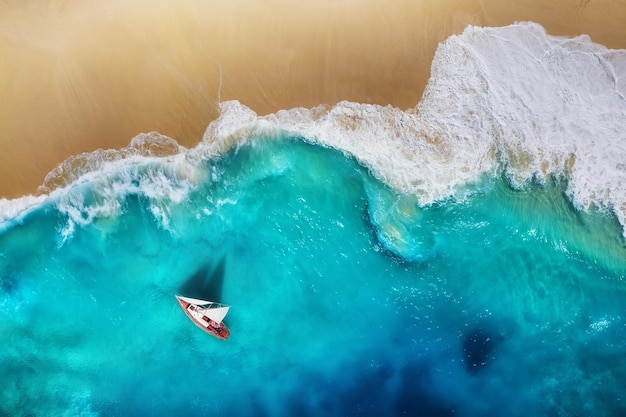 Yacht auf dem Meer aus der Draufsicht Türkisfarbener Wasserhintergrund aus der Draufsicht Strand und Wellen Sommerseelandschaft aus der Luft Reisebild