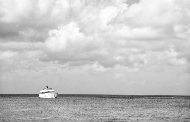 Yacht auf dem Wasser und grauer bewölkter Himmel bei launischem Wetter im Freien auf Horizontlinie Hintergrund kopieren Raum