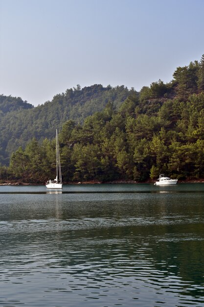 Yacht segelt auf dem Meer entlang der Berge