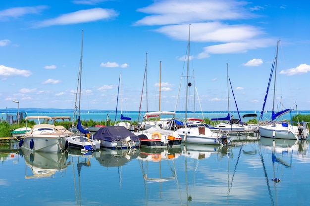 Yachten sind am Ufer eines Sees mit türkisfarbenem Wasser festgemacht