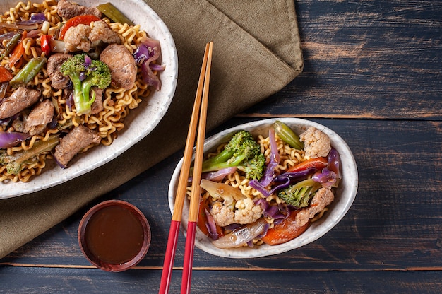 Yakisoba, famosos fideos fritos japoneses, con carne y verduras. Vista superior