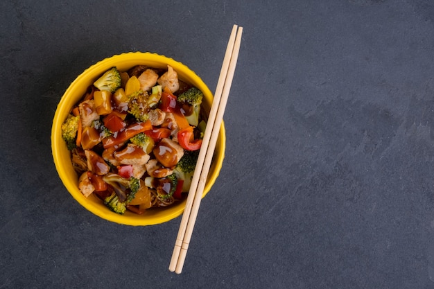 Yakissoba de pollo en tazón de fuente amarillo.