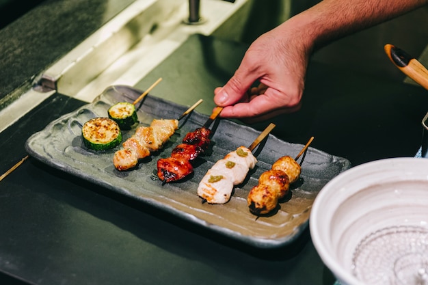 Yakitori (espetos de frango grelhado em estilo japonês) com frango, órgão interno e pepino.