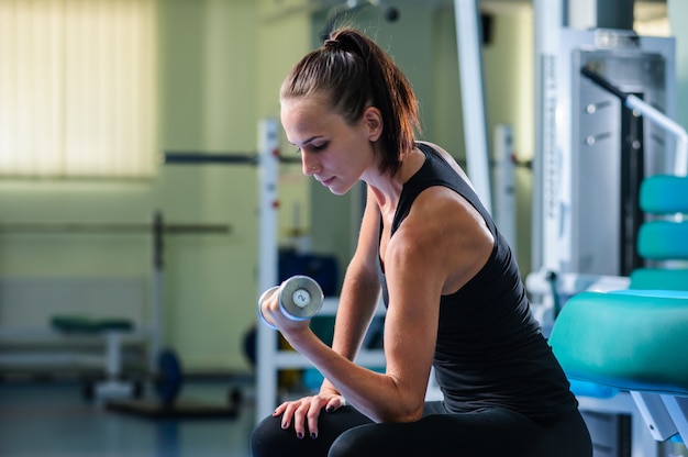 Yang hübsche Frau trainiert im Fitnessstudio