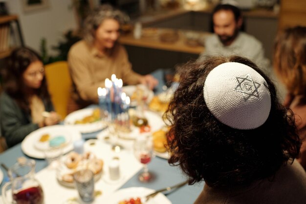 Yarmulke blanco con estrella de plata de David en la cabeza de un joven judío