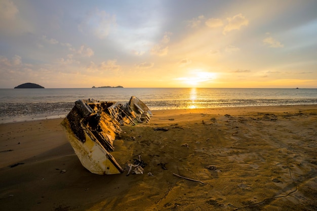 Yate abandonado en la playa tomado al atardecer