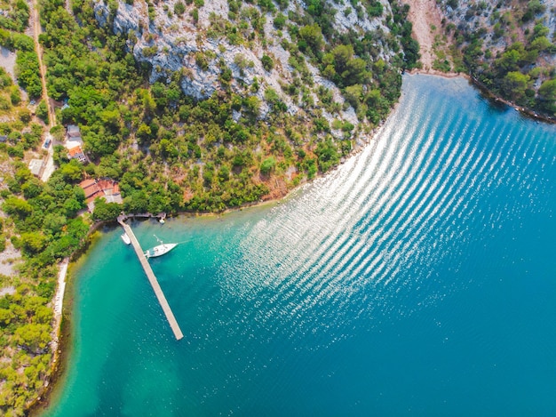 Yate en el agua de la bahía azul del muelle