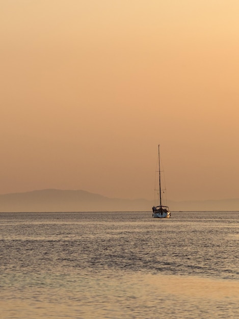 Yate al atardecer en la isla en el Mar Mediterráneo en Grecia